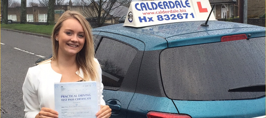A newly qualified driver with her pass certificate beside the Calderdale School of Motoring car